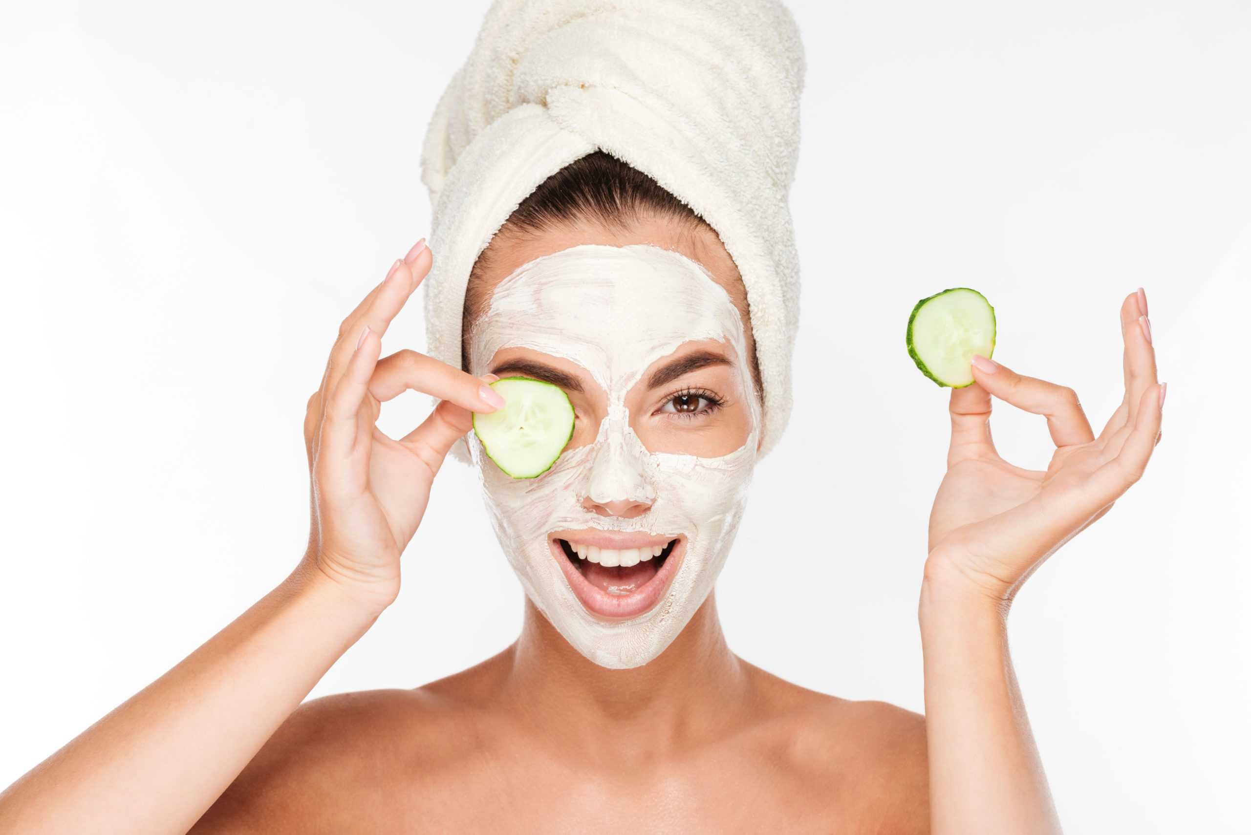 woman with facial mask and cucumber slices in her hands on white background SBI 302779403 3 scaled
